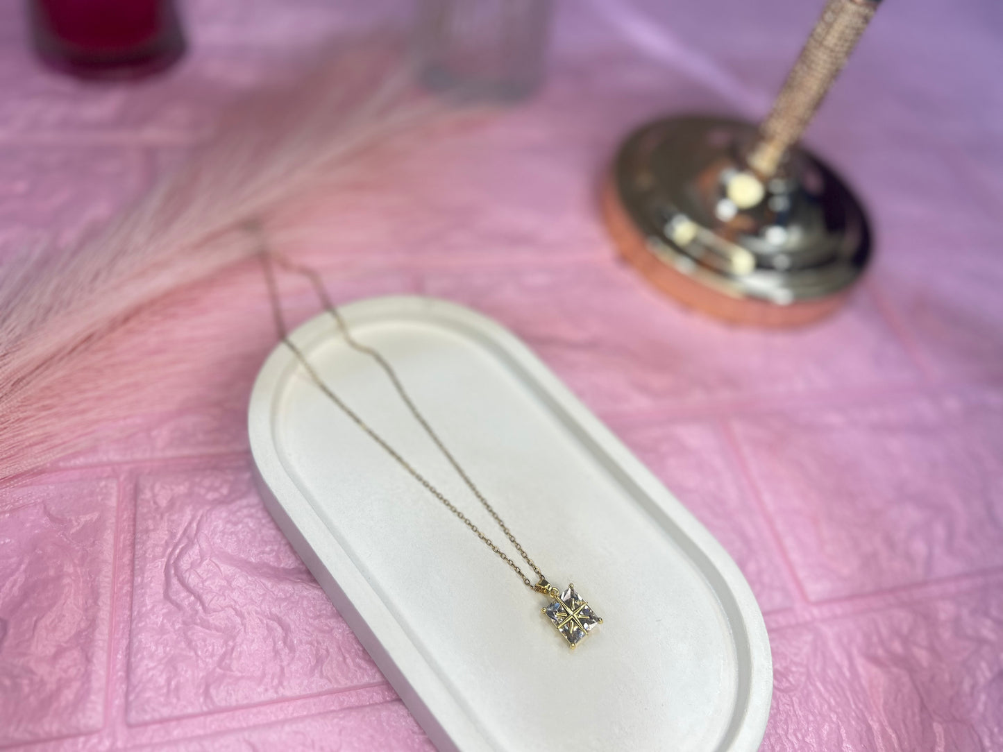 Necklace with a star-shaped pendant on a pink textured surface