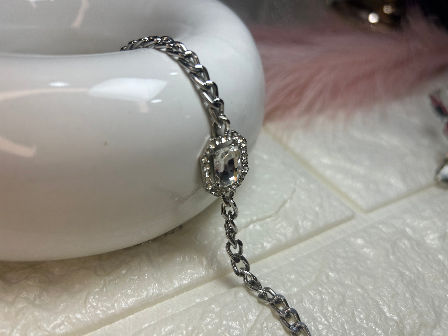 Silver bracelet with a decorative clasp on a textured surface