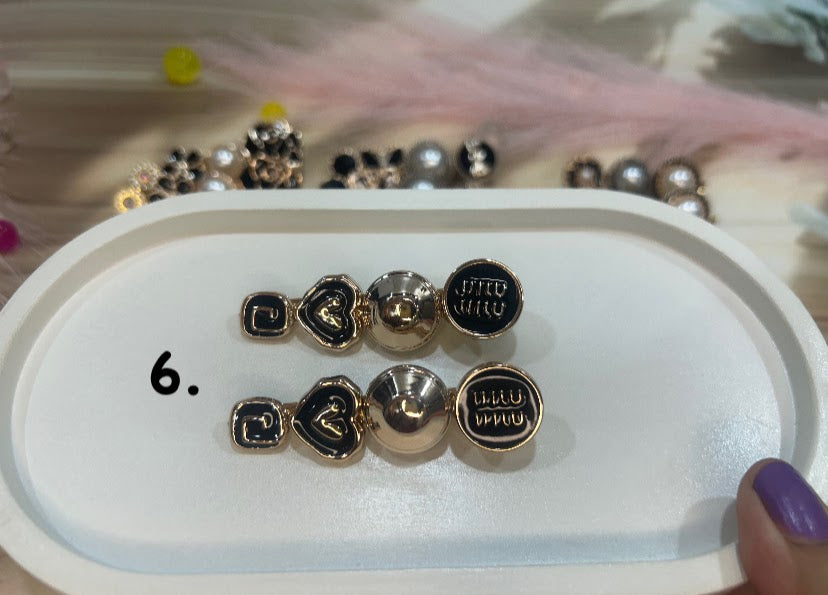 Set of gold and black hair clip on a white tray with a blurred background