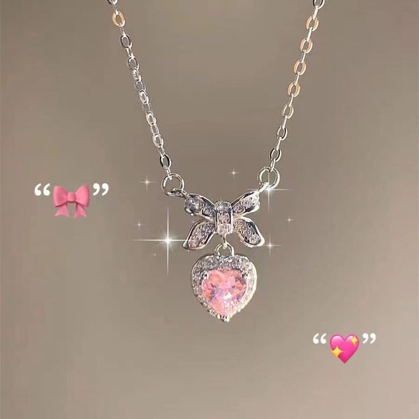 Necklace with butterfly and heart-shaped pink gemstone pendant on a soft brown background