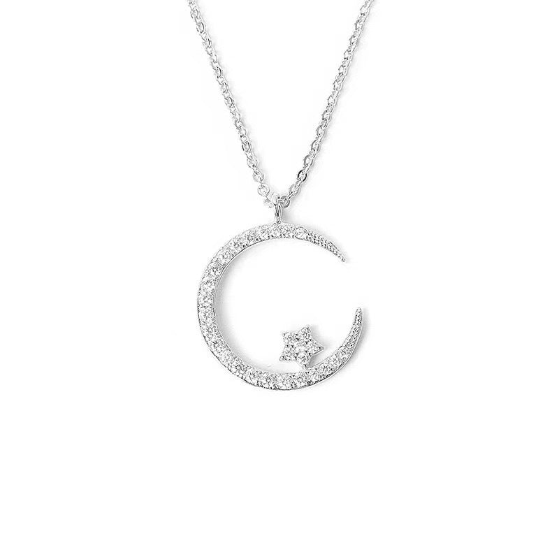 Silver necklace with a crescent moon and star pendant on a white background