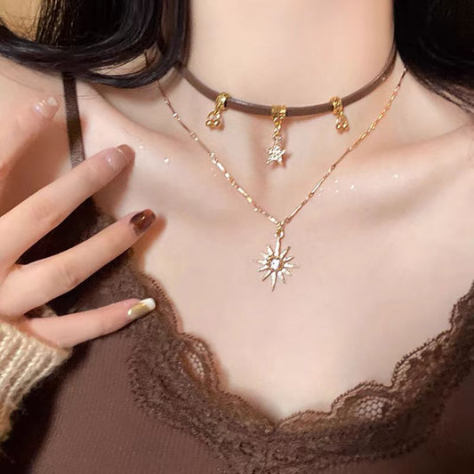 Close-up of a person wearing a gold necklace with a star pendant, against a neutral background.
