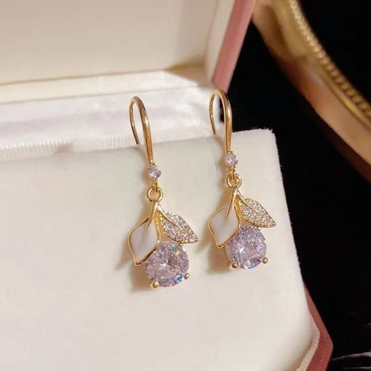 Gold earrings with gemstones on a white surface