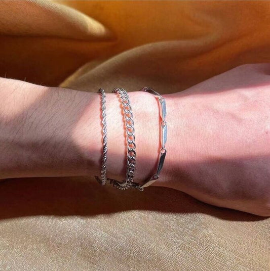 Close-up of a wrist wearing multiple bracelets on an orange fabric background