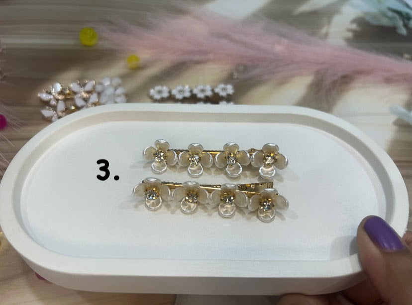 Gold and clear hair clip set on a white tray with a blurred background