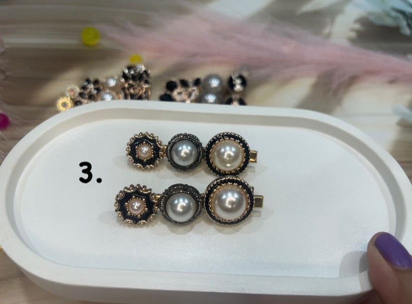 Set of pearl hair clip on a white tray with a blurred background