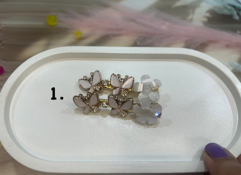Butterfly-shaped hair clip on a white tray with a blurred background