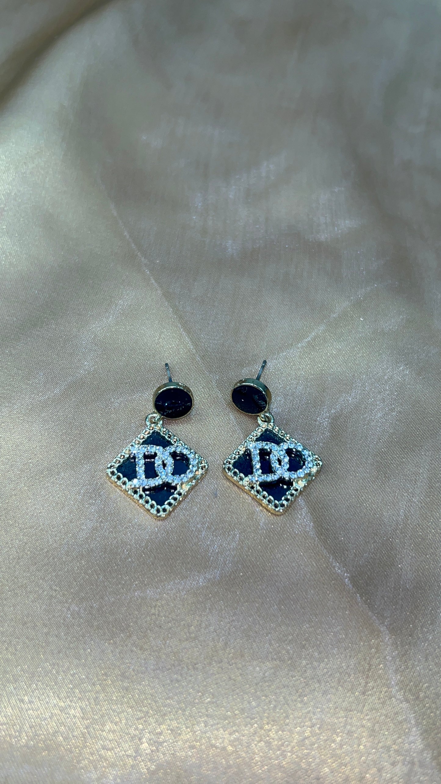 Pair of earrings with blue gemstones on a light fabric background