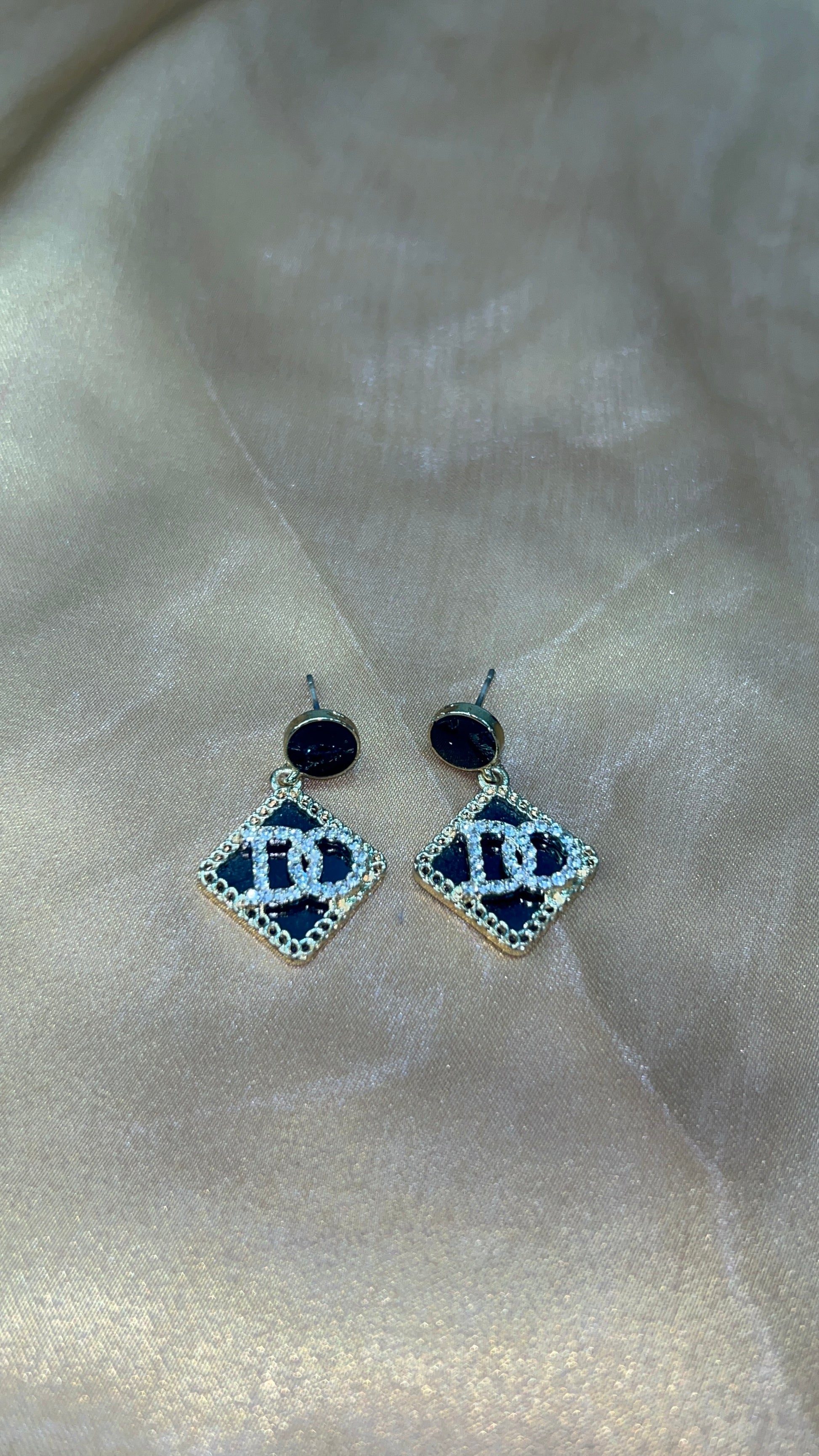 Pair of earrings with blue gemstones on a light fabric background