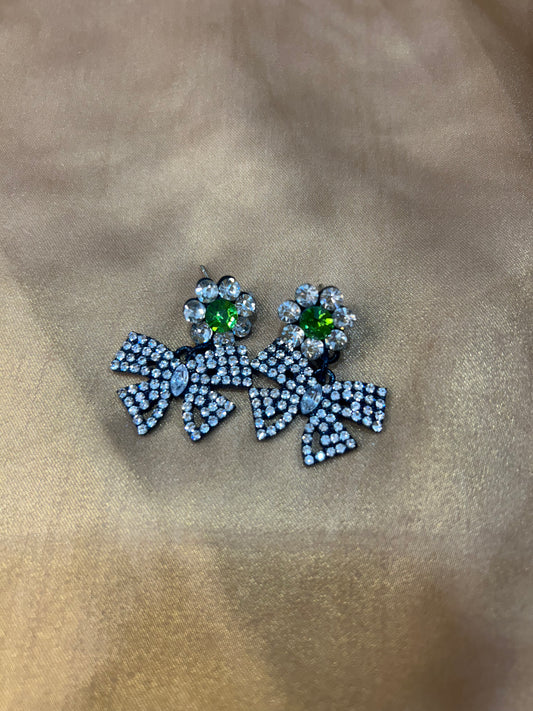 Pair of earrings with gemstones on a beige fabric background