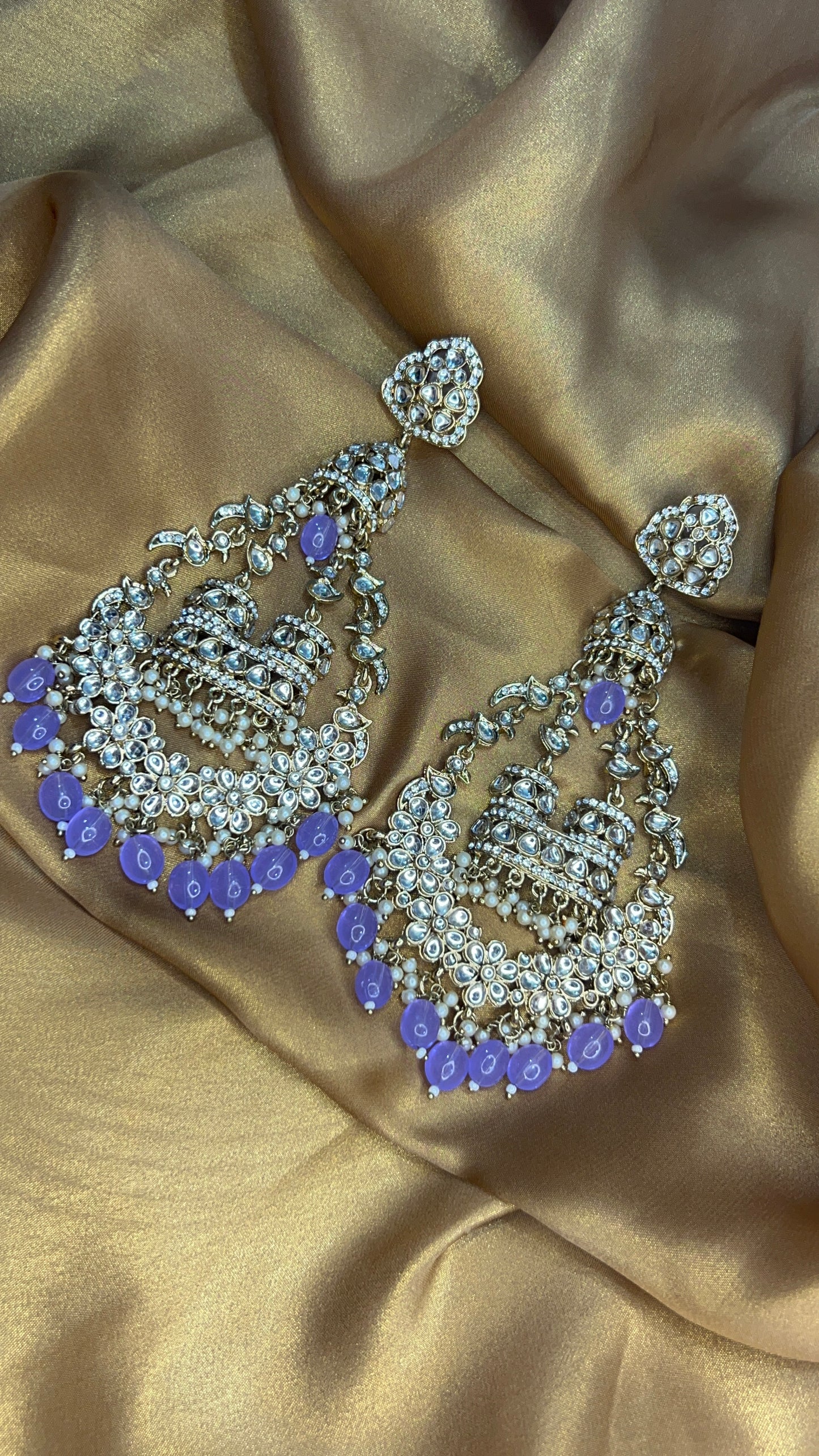 Jewelry set with purple stones on a gold satin background