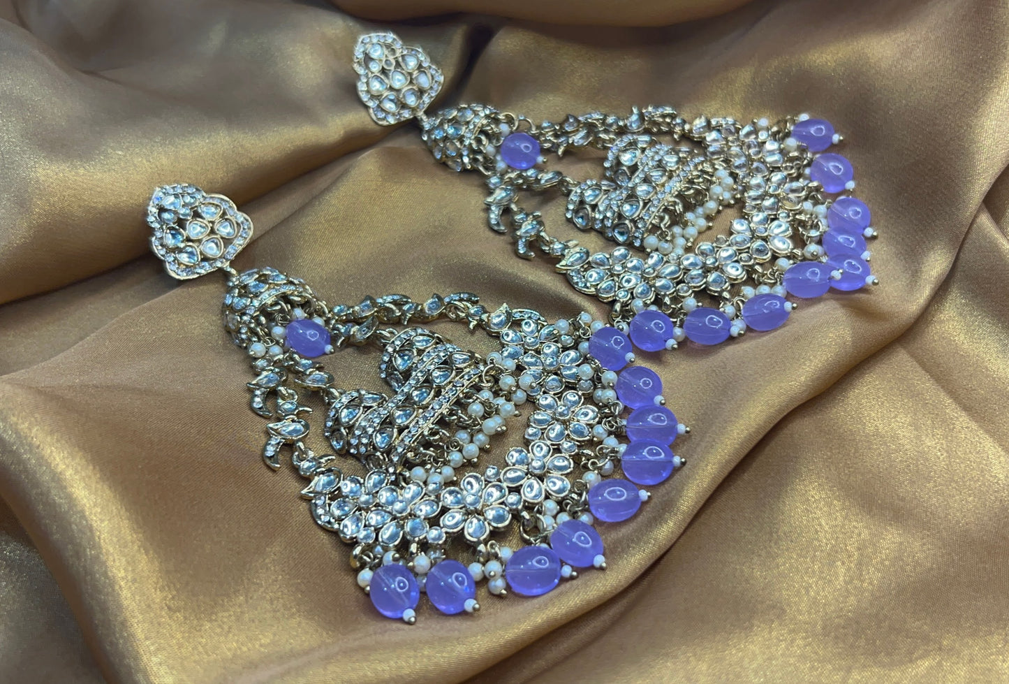 Ornate jewelry set with purple stones on a gold fabric background