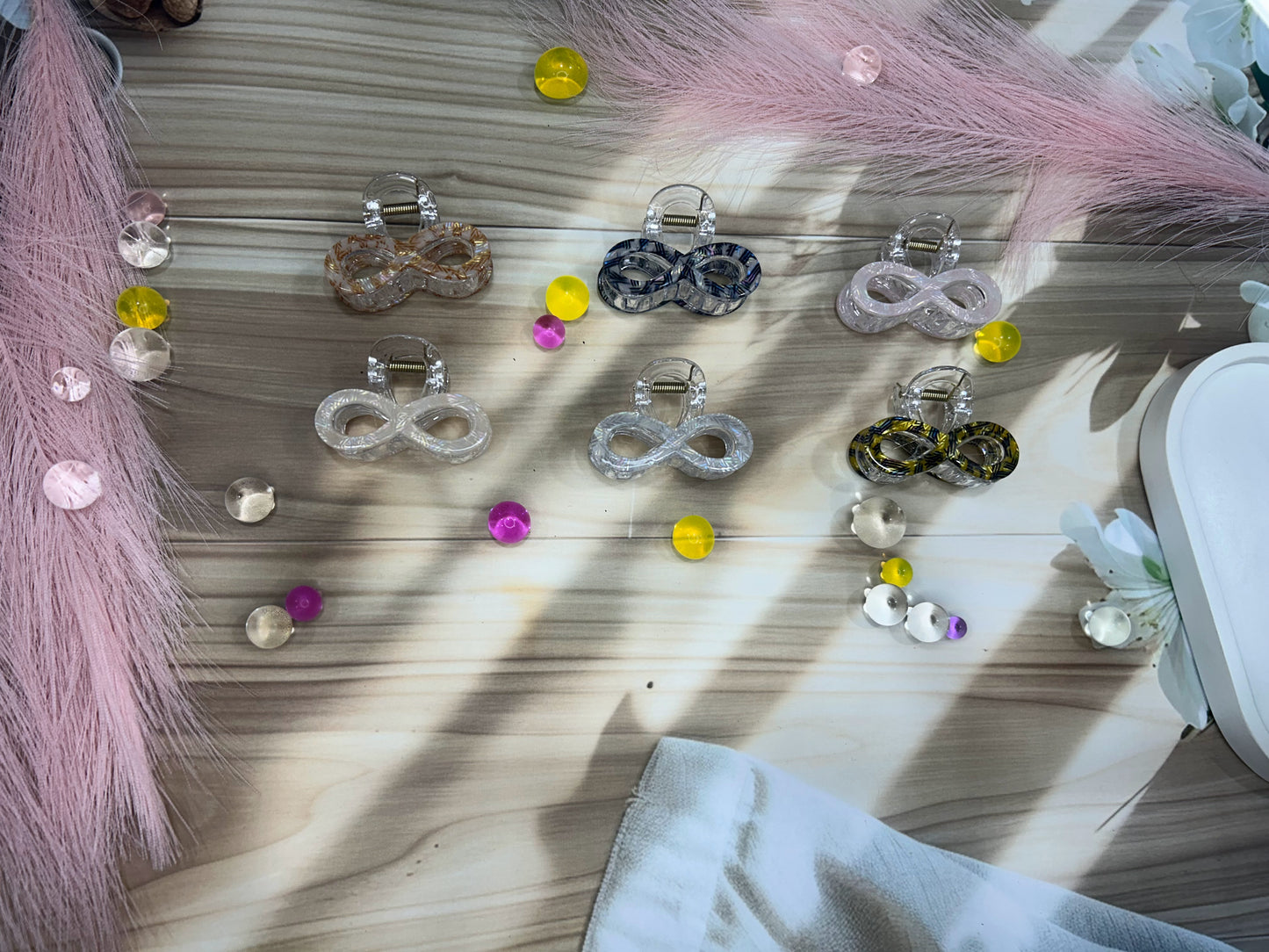 Set of hair accessories including clips and pins on a wooden surface with decorative elements.