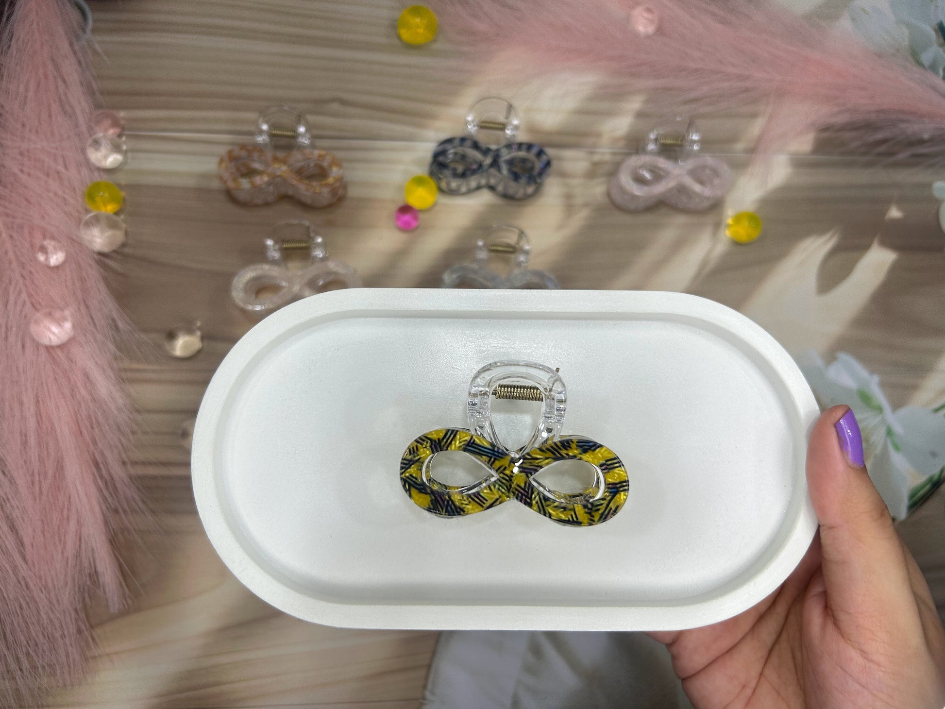 Claw on a white box with a blurred background of more earrings.