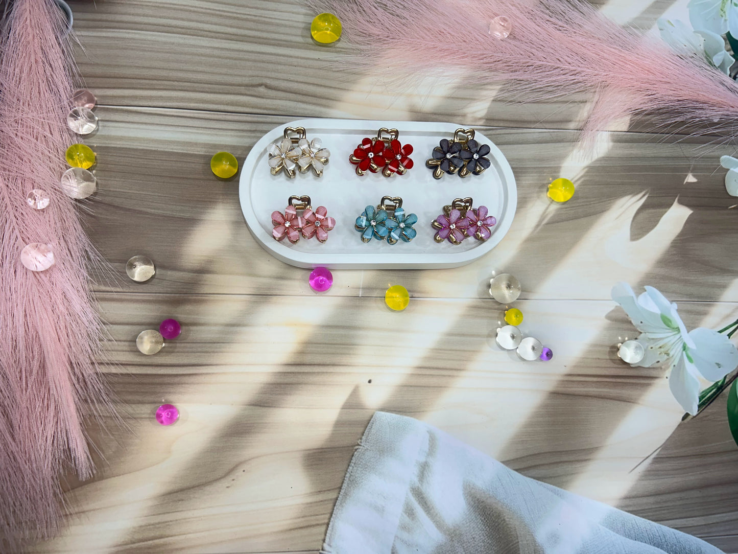 Set of colorful hair accessories on a wooden surface with decorative elements.