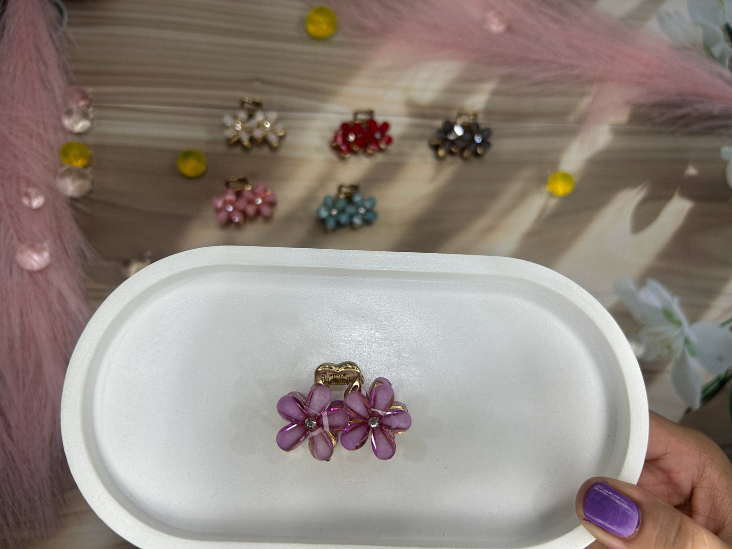 Purple flower-shaped earrings on a white dish with blurred background