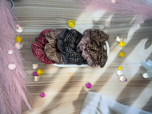 Three patterned headbands on a white surface with decorative elements.