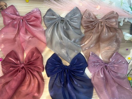 Set of colorful satin hair bows on a wooden surface