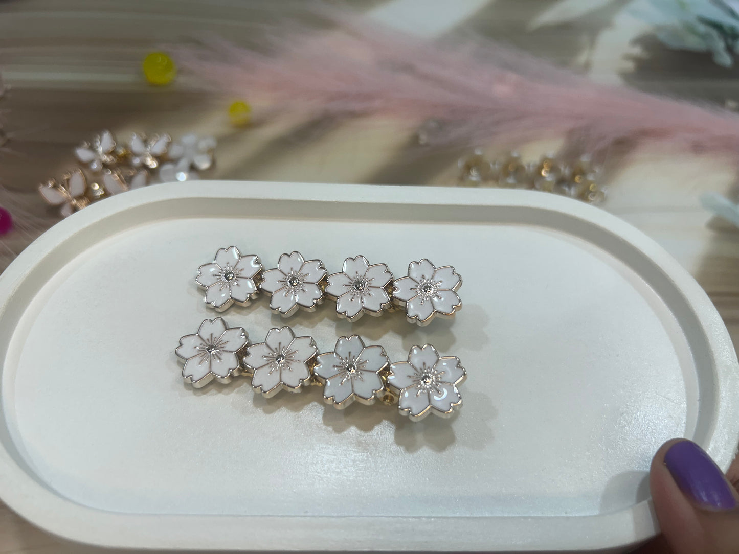 Set of silver floral hair clip on a white tray with a blurred background