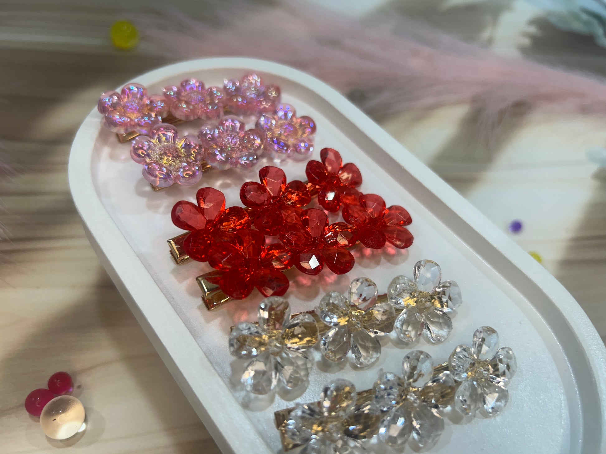 Colorful hair accessories on a white tray with a blurred background