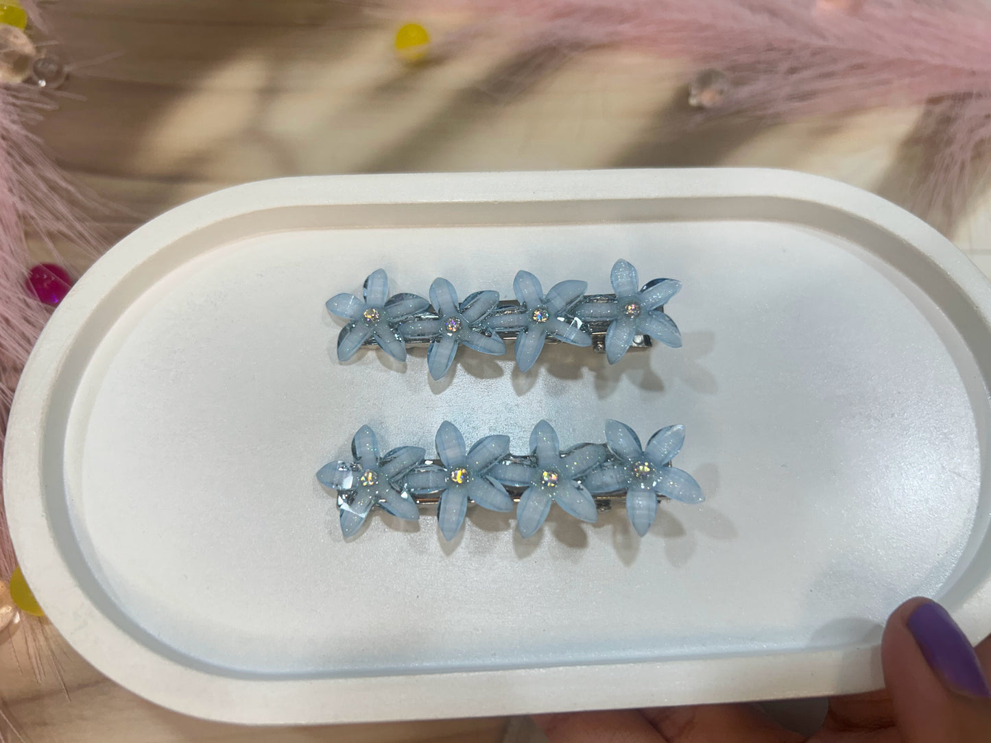 Blue floral hair accessories on a white tray with a blurred background