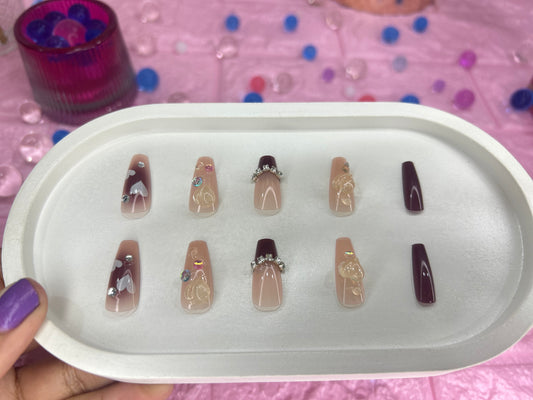 Set of nail designs on a tray with a pink background
