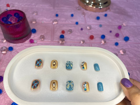 Set of snail arts displayed on a white tray with a pink background