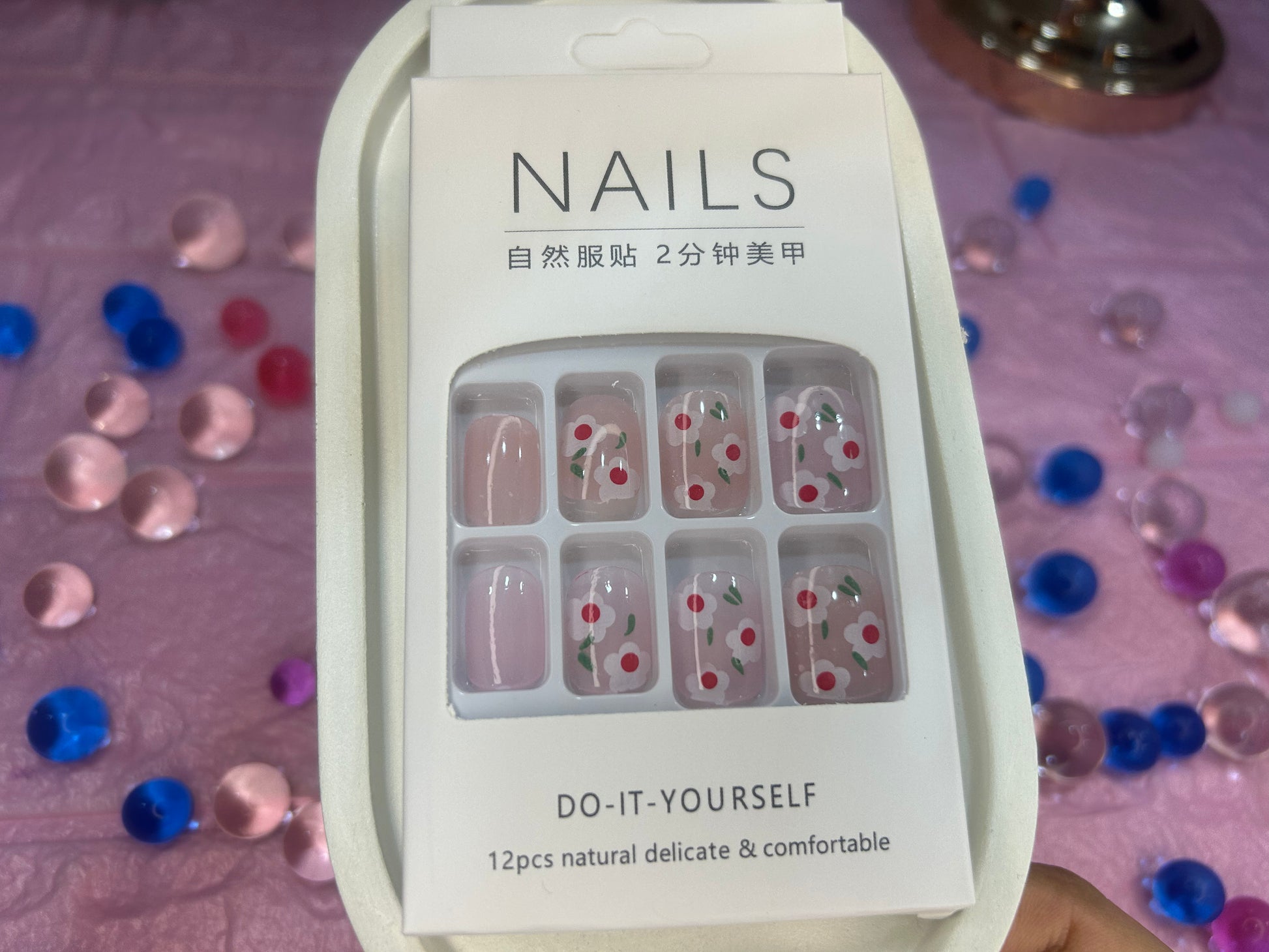 Packaging of nail art stickers with decorative designs on a colorful confetti background.