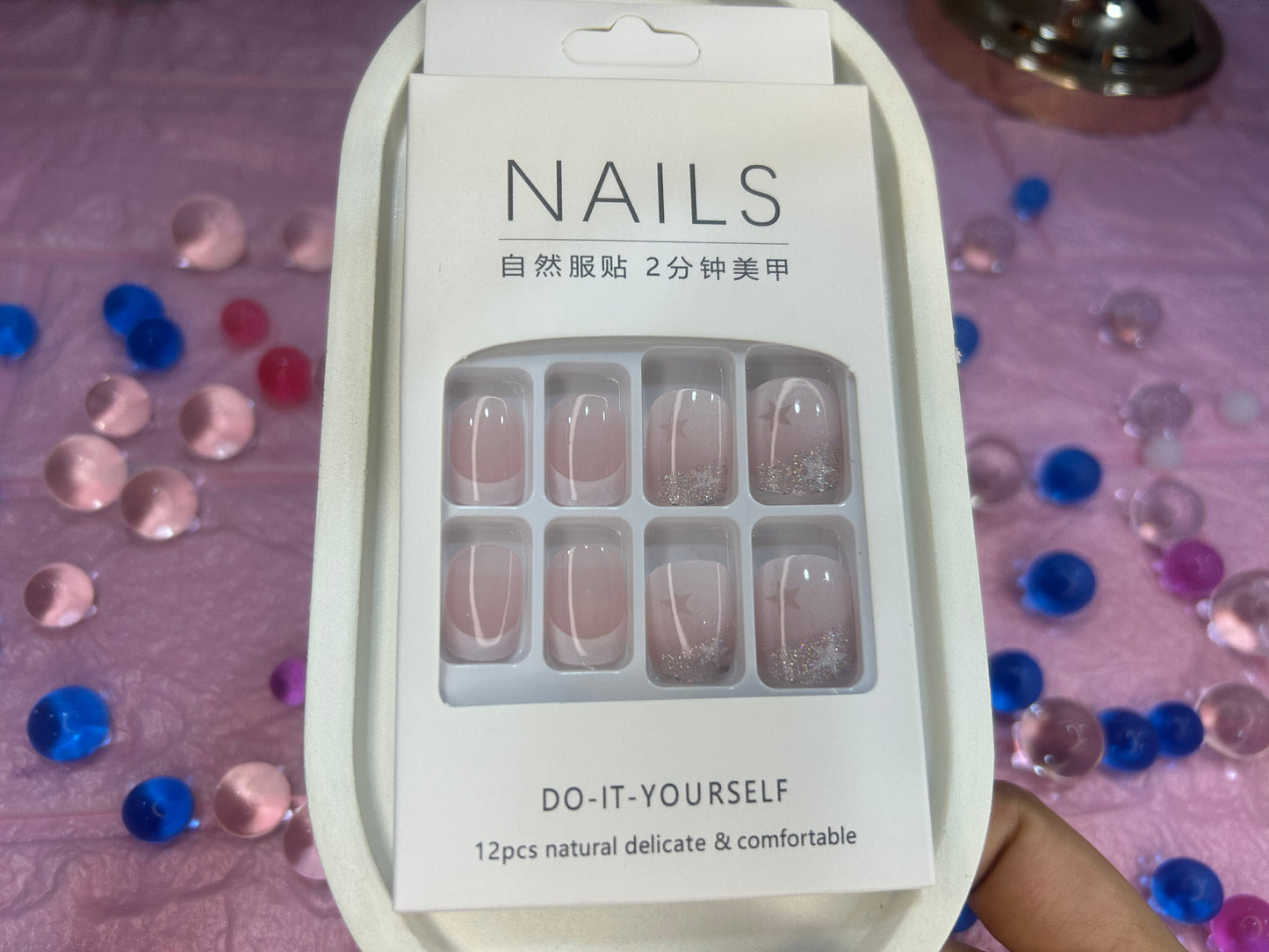 Packaging of nail stickers with confetti in the background