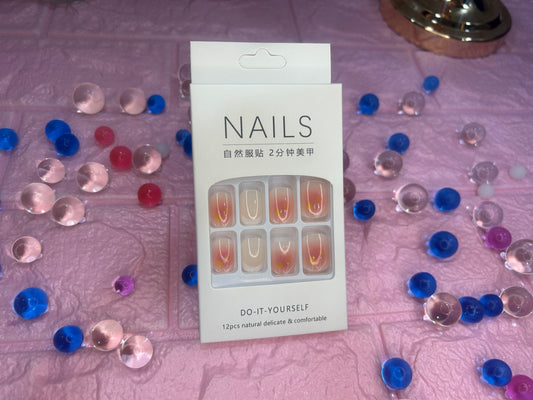 Nail art kit packaging with decorative nail tips on a patterned surface
