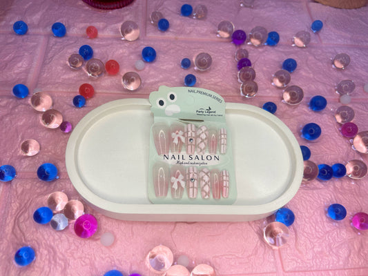 Nail art design kit on a pink surface with decorative stones