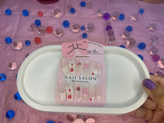 Pack of nail salon clips on a pink tray with colorful beads in the background