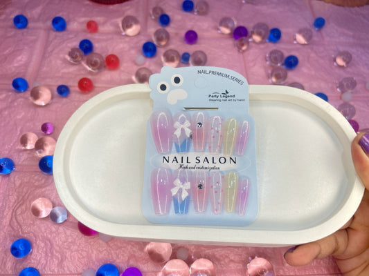 Nail salon product packaging on a pink surface with decorative stones.