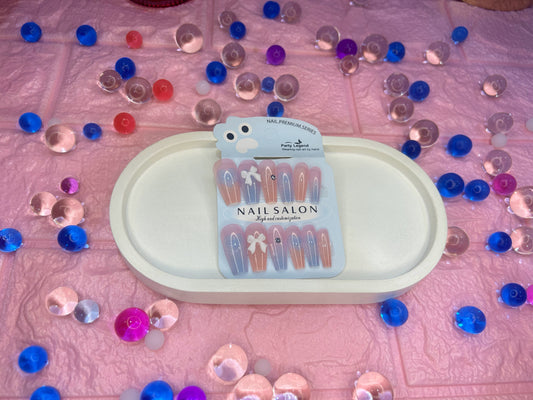 Nail art tools with a packaging label on a pink surface with confetti