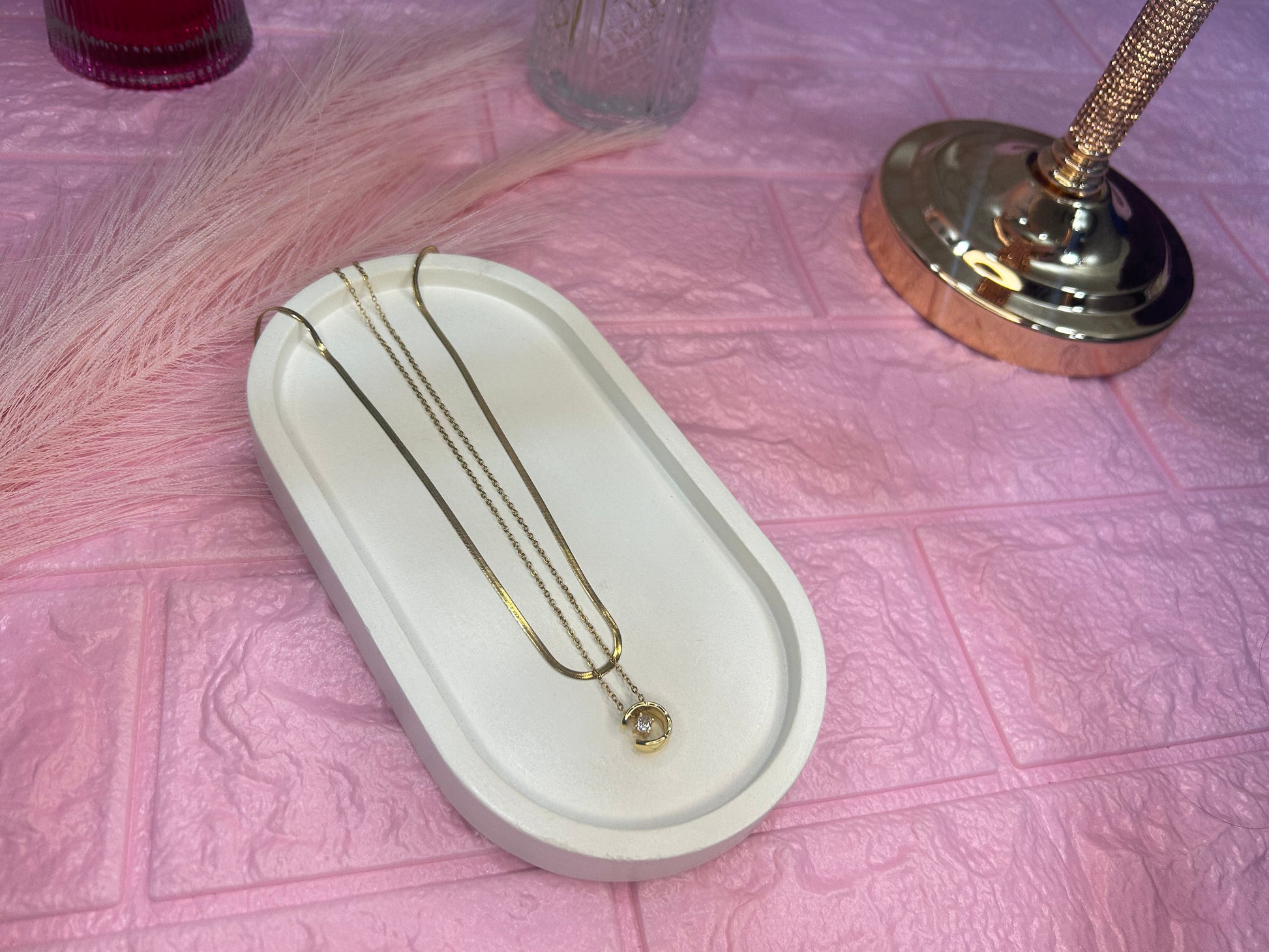Jewelry box with a necklace on a pink textured surface