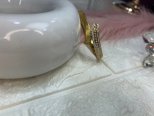 Gold ring with a textured band on a white surface