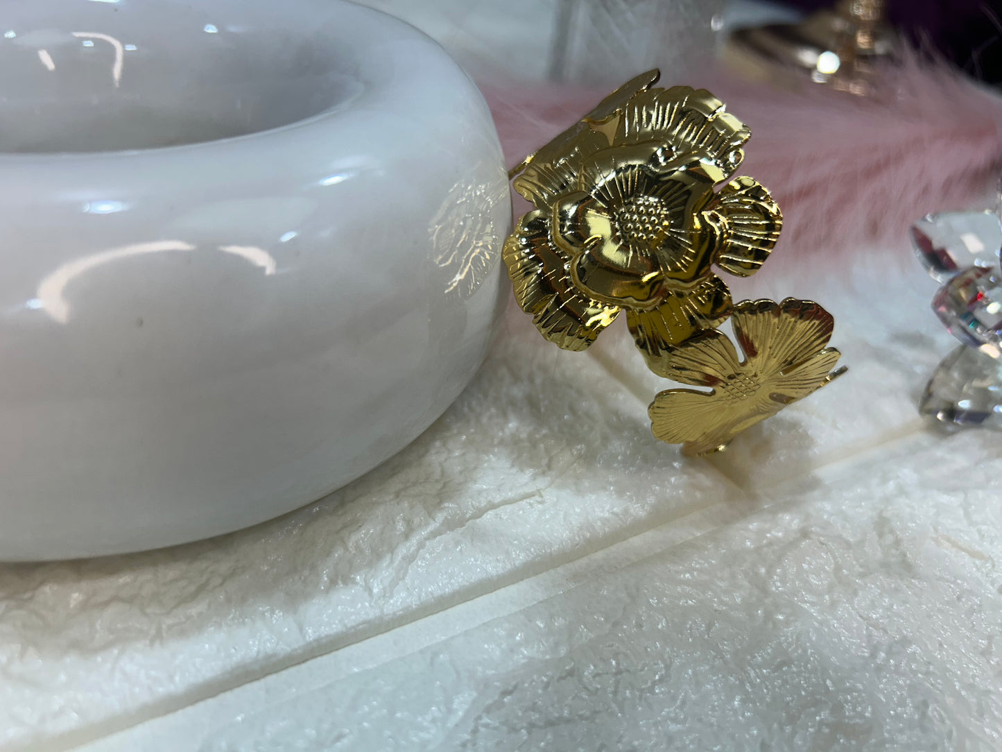 Gold flower-shaped earring on a white surface