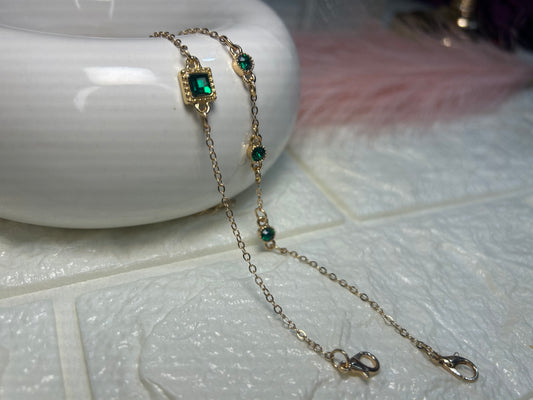 Bracelet with green gemstones on a white surface