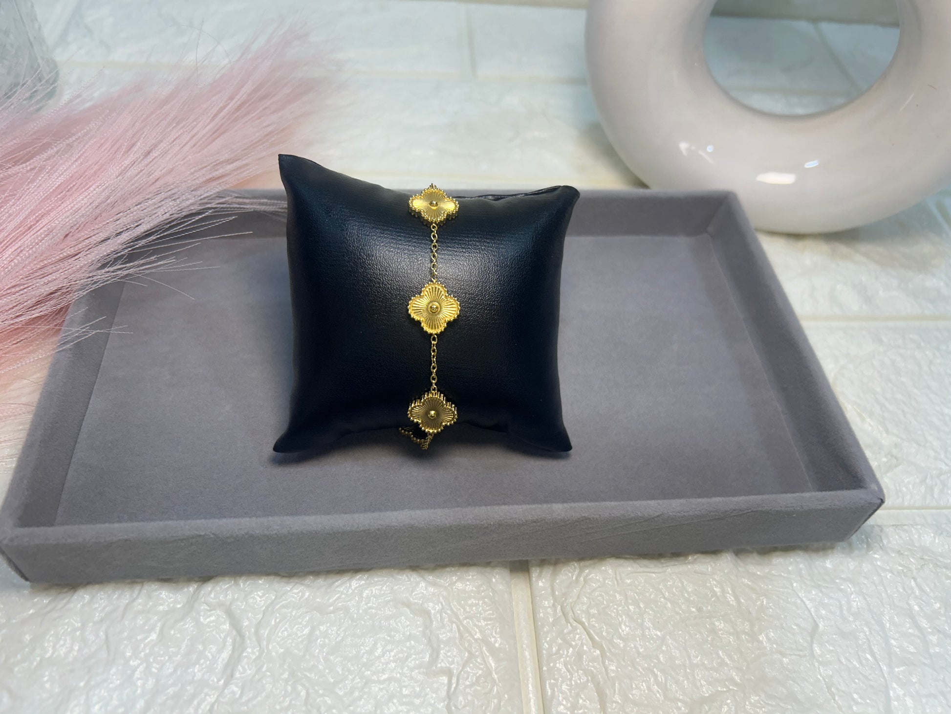 Black jewelry pillow with gold earrings on a gray tray