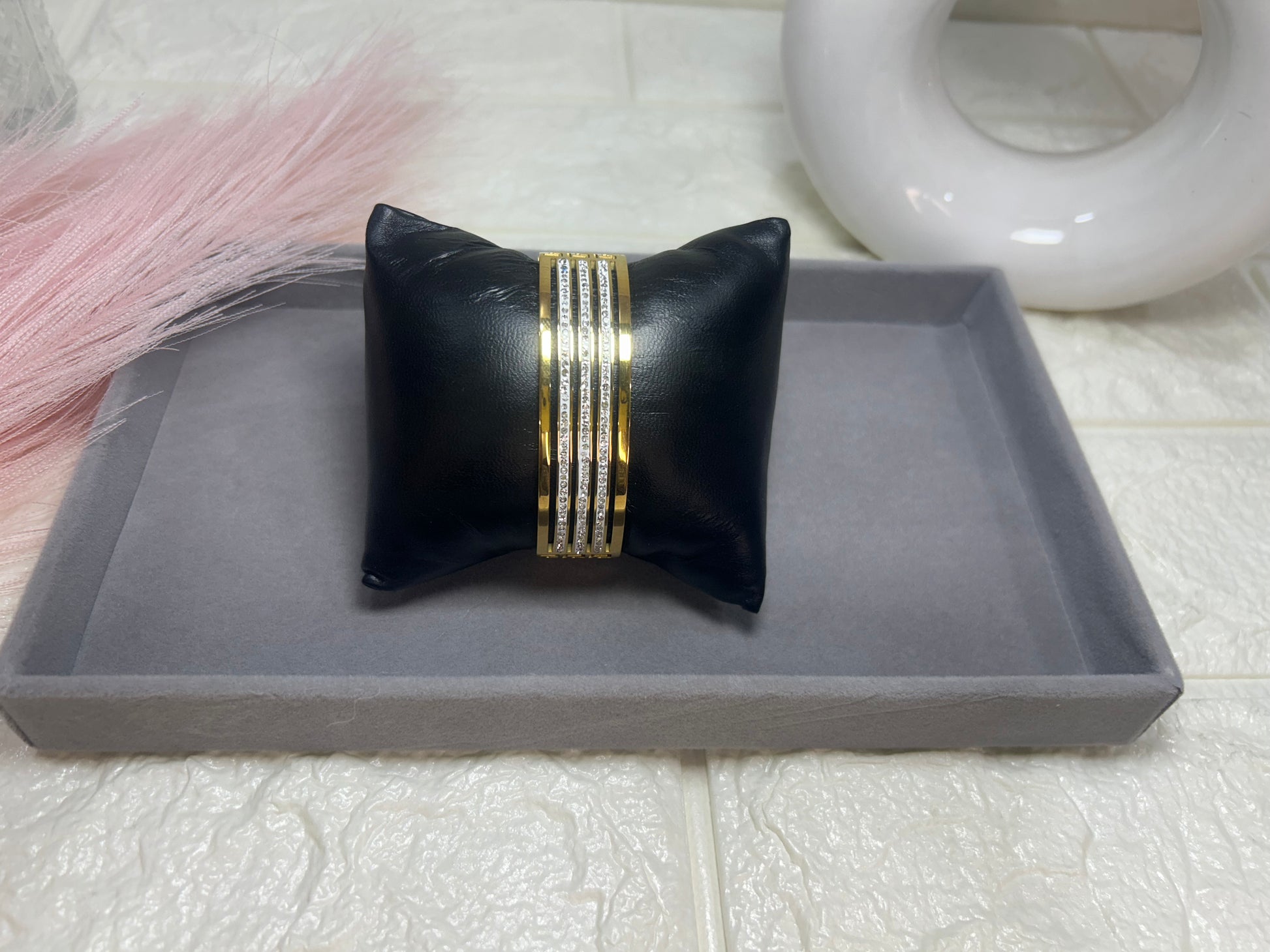 Black jewelry box with gold accents on a gray tray