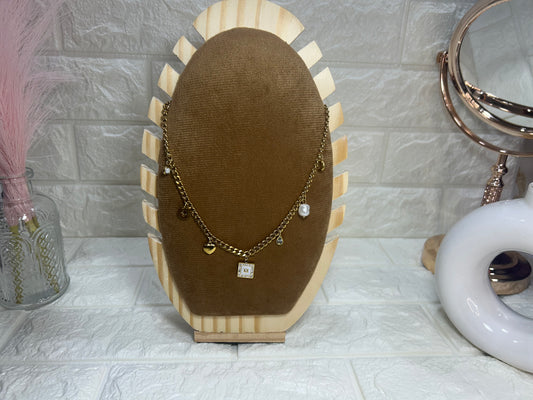 Necklace on a brown velvet stand with decorative items in the background