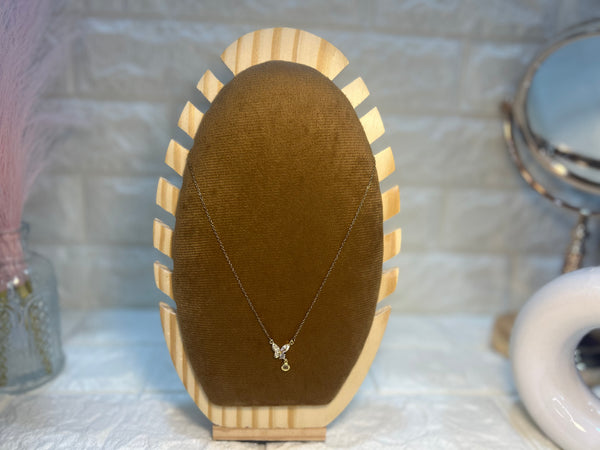Necklace on a wooden display stand with a brown velvet surface