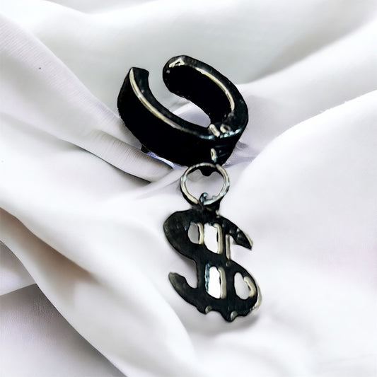 Black hoop earring with a dollar sign charm on a white fabric background